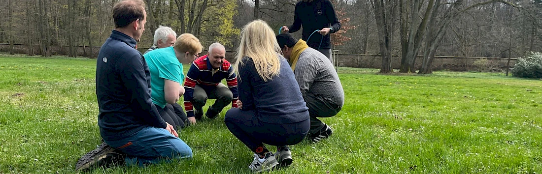 Team hockt auf der Wiese, um gemeinsam Lösungen zu finden